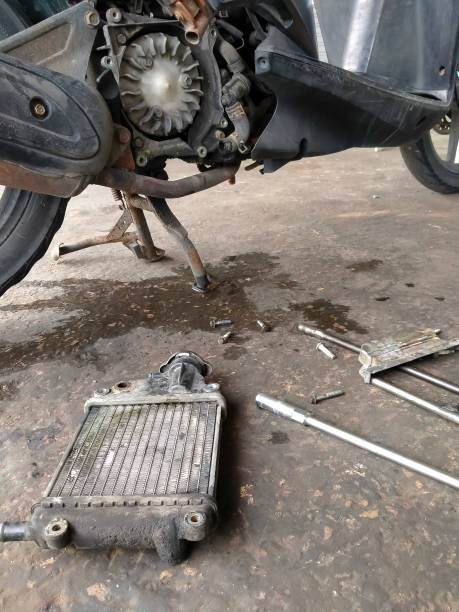 istock Low section of the old motorcycle with broken radiator on the floor while waiting for maintenance at the garage 1412455976