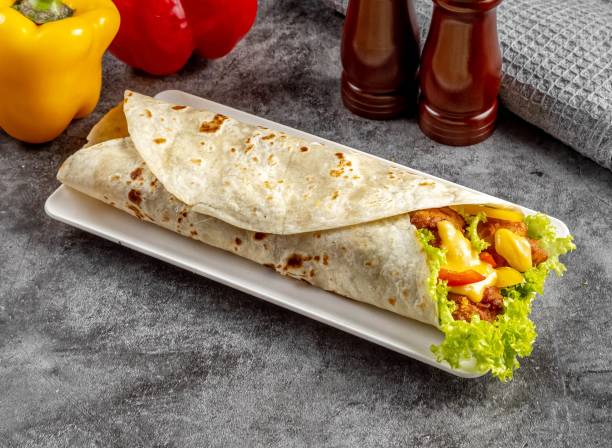 Salted Egg Crispy Chicken shawarma Wrap served in a cutting board on grey background side view of fastfood