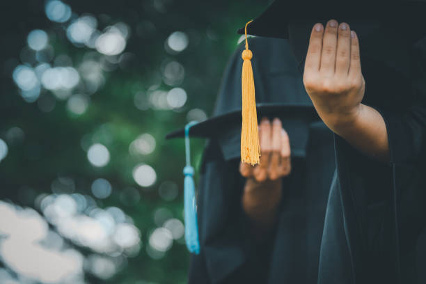 istock graduates holding a hat At the graduation ceremony at the university 1412457666