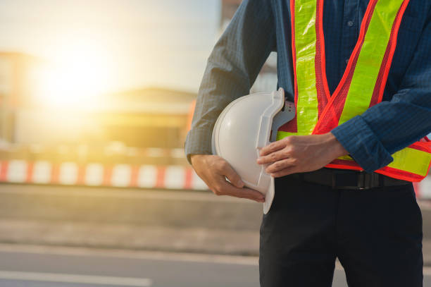istock Close up hand holding white helmet hard hat Engineering concept,Technician holding white hat safety hard hat sunlight background 1412458589