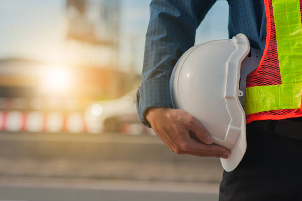 istock Close up hand holding white helmet hard hat Engineering concept,Technician holding white hat safety hard hat sunlight background 1412458613