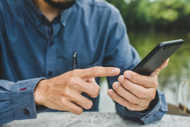 istock Close up man using mobile smart phone ,business, people, cellphone, touchscreen, touchphone, cell, businessman, smartphone, phone, telephone, lifestyle, technology, device 1412458656