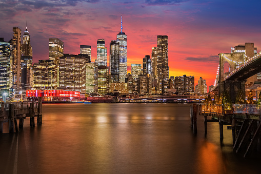 New York City Skyline with Brooklyn Bridge, Manhattan Financial District and World Trade Center, Illuminated at Night, Water of East River and Vivid Yellow Orange Blue Sunset Sky. Canon EOS 6D (full frame sensor) DSLR and Canon EF 24-105mm F/4L IS lens. HDR image.