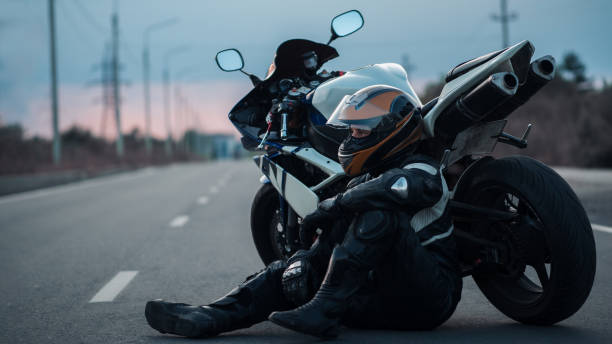 istock A motorcyclist is sitting on the road by a motorcycle 1412459778