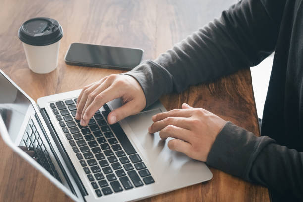 istock Businessman taking notes Summarize the meeting online with laptop, working alone, sitting at your desk. Working from home, close-up hands. 1412460165