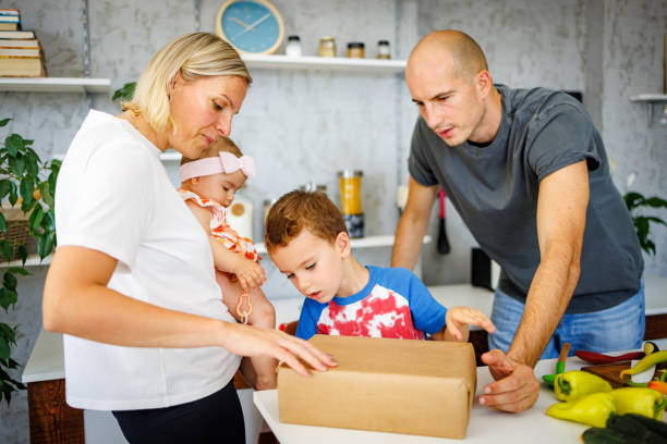 istock Young family unpacking carboard box in kitchen 1412460433