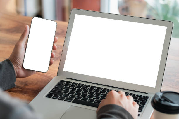 istock Mockup Copy Space Computer Notebook Laptop and smartphone Concept , a man's hand using a laptop on internet websites at the office, keyboards on laptop computer with balnk copy screen for your advertising content. 1412463122