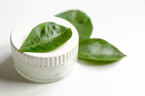 Ecological cosmetic skincare product container with green leaves