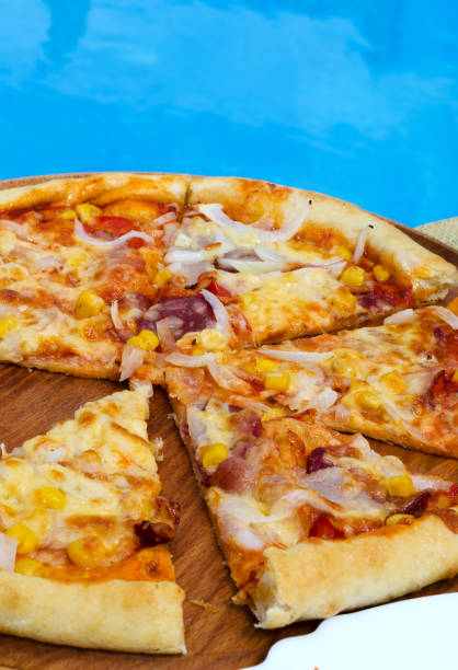 istock Pizza cut into slices on the background of a blue pool. 1412465948