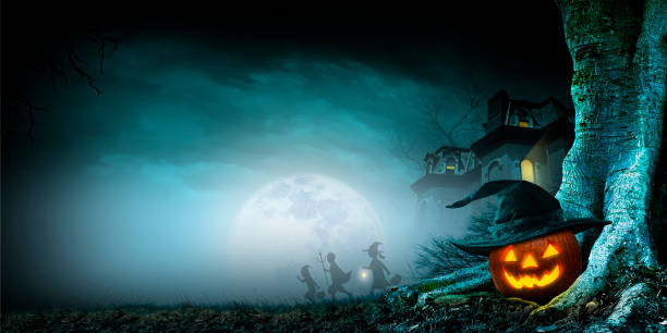 Three children in the distance scurry way from a haunted house as they pass by an illuminated jack o'lantern nestled in the trunk of  a barren spooky tree while trick or treating on a foggy and misty Halloween night.