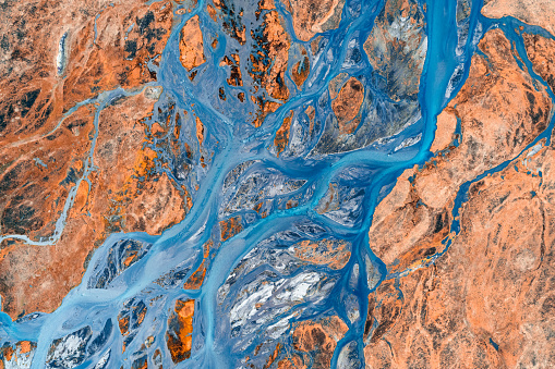Top view of abstract glacier rivers pattern flowing through volcanic lava field in Icelandic highlands on summer