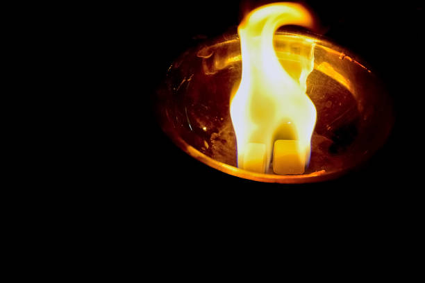 istock Orange colored fire flame rising from a goblet bowl with a reflection in the wall of  it. 1412470250