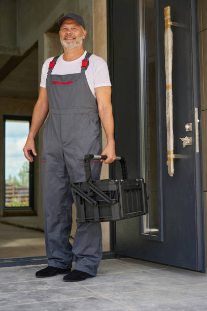 istock Portrait of smiling worker in overalls and with tool box 1412474796