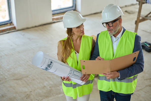istock Foreman holds open folder and discusses with real estate manager 1412476161
