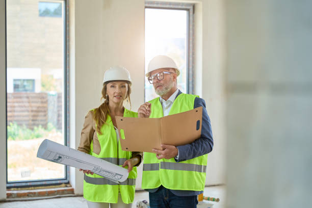 istock Real Estate Agent with drawings, and foreman with folders in their hands 1412476184