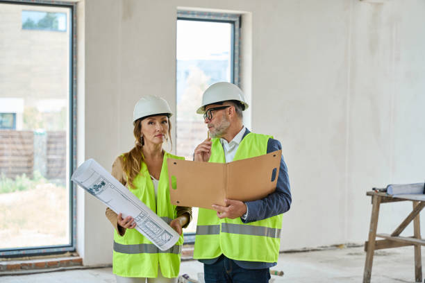 istock Real estate agent with blueprints and foreman with folders 1412476212