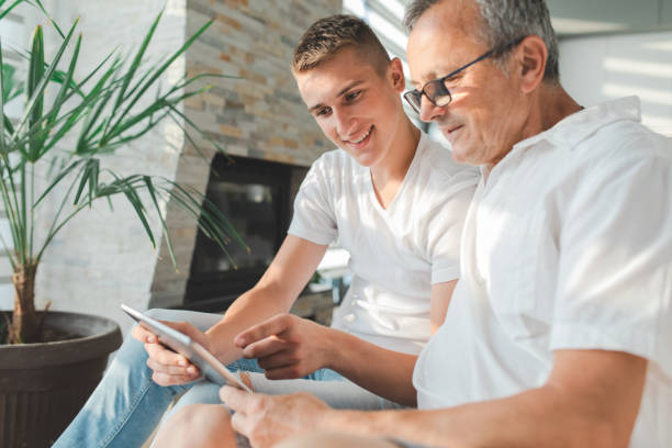 istock Grandson and Grandfather Using Digital Tablet at Home 1412478430