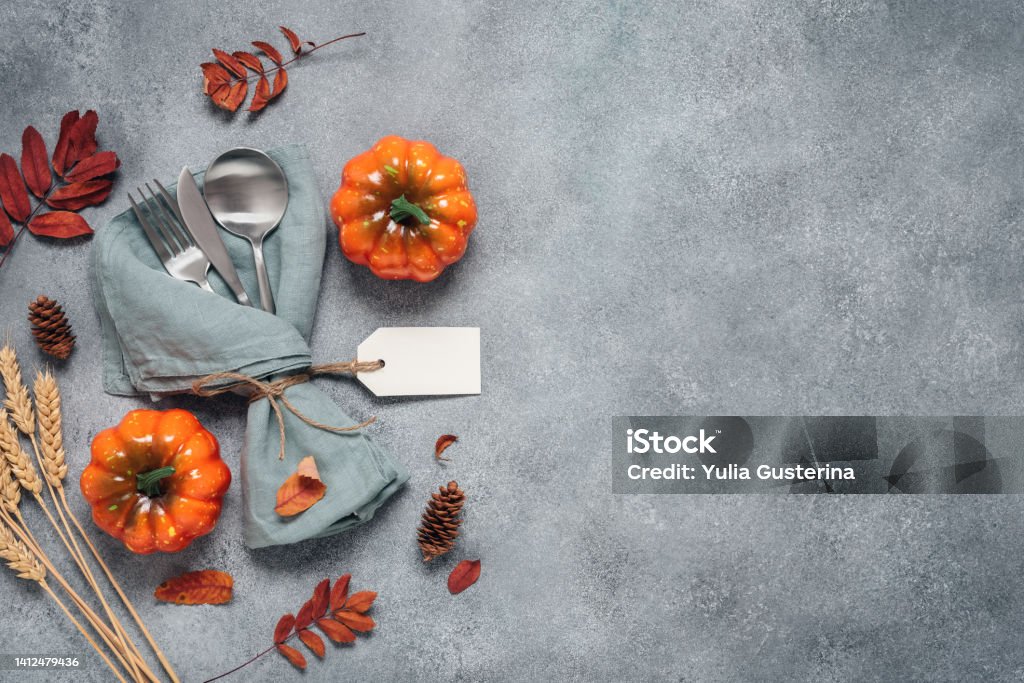 Thanksgiving autumn place setting with cutlery, decorative pumpkins and colorful leaves. Top view, flat lay., copy space. Selective Focus Arrangement Stock Photo