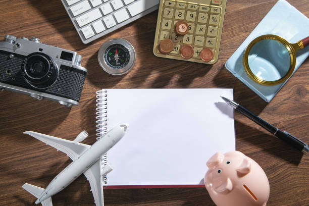istock Calculator, notepad, coins, retro camera, airplane on the wooden background. 1412481281