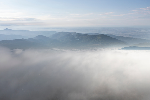 Aerial view of misty mountains at sunset.