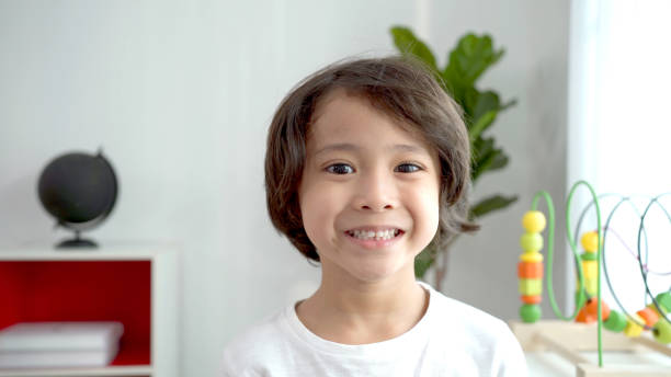 istock Happy Asian boy waving hand to camera. 1412489565