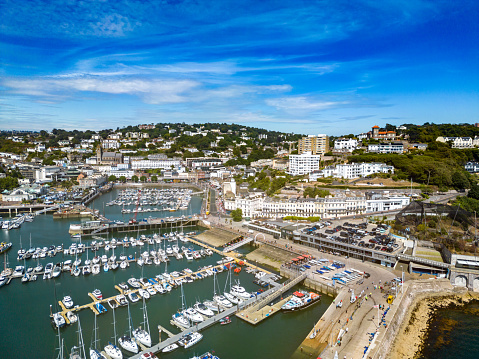 Torquay, UK. 29 July 2022. View over boats in the harbour in Torquay with shops and restaurants.