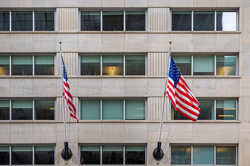 New York, NY, USA - June 23, 2022: Façade of a office building with two American flags on 5th Avenue in midtown Manhattan close to West 51st Street