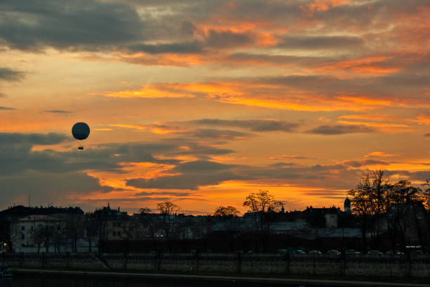 A bright orange sunset in Krakow, Poland. A city evening landscape with a balloon on the Vistula promenade