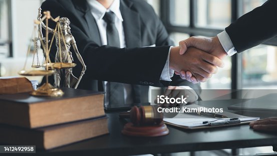 istock Lawyer and client shake hands, after winning a lawsuit where a lawyer hired by a client in a fraud case and proceeding in a fair and correct manner, the client wins the case. Fraud litigation concept. 1412492958