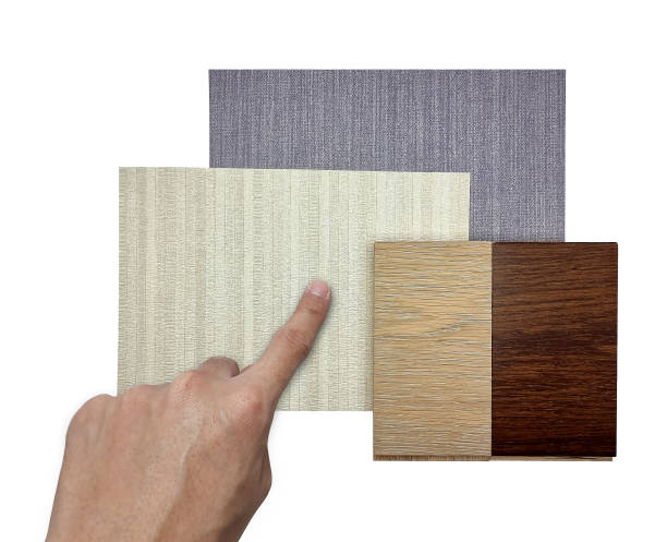 istock architect's hand choosing interior material samples including beige and grey fabric wallpaper, oak and italian walnut engineering flooring isolated on white background with clipping path. mood board. 1412494379