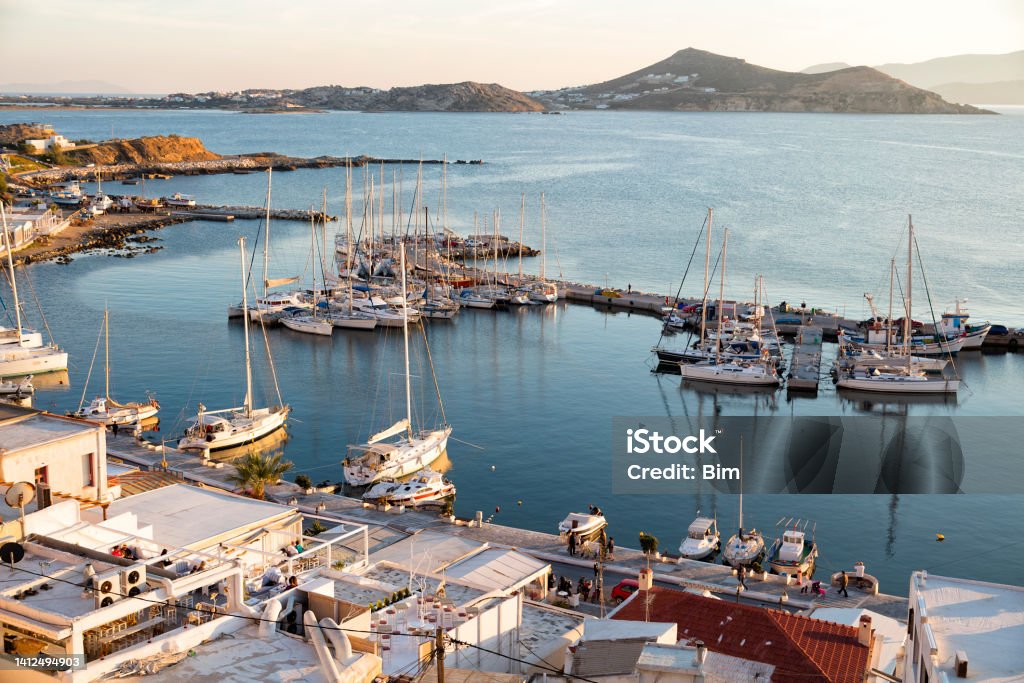 Naxos Town at Sunset, Cyclades Islands, Greece The Chora ("capital") of Naxos island at sunset in the Aegean Sea, Cyclades, Greece, Europe. Port with moored pleasure boats is seen in the foreground. Naxos - Greek Islands Stock Photo