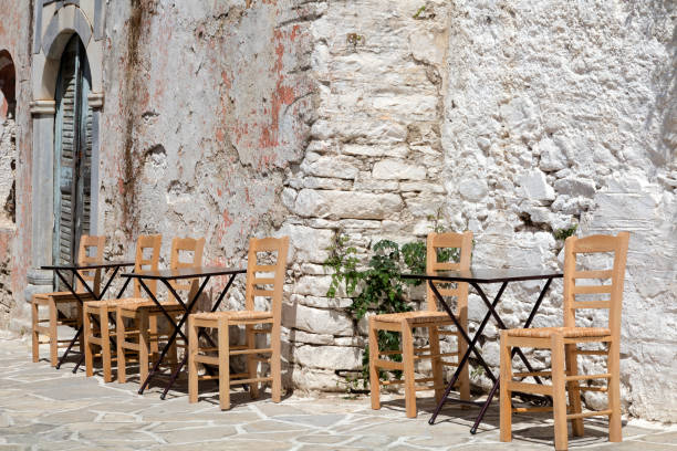 tables and chairs in street restaurant, naxos, greece - greek culture bar restaurant greece imagens e fotografias de stock