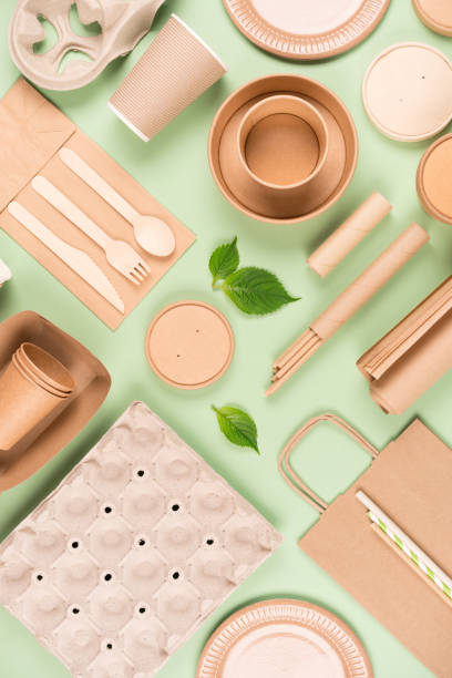 istock Vertical flat lay composition with eco tableware, paper utensils and wooden bamboo cutlery set over light green background. Sustainable food packaging concept 1412498202