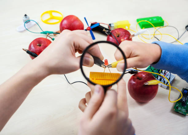 istock School experiment with apples. School students extract electricity from apples, use of the energy of a chemical reaction. STEM and STEAM education. 1412500956
