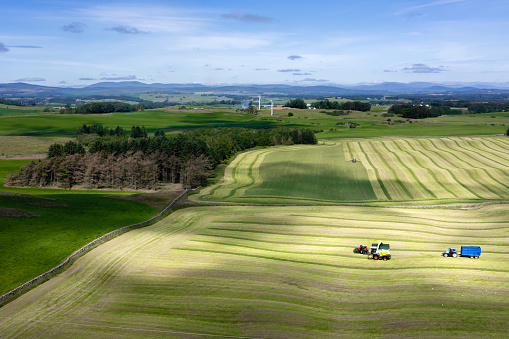 Aerial view of tractors working in a field harvesting silage in rural Dumfries and Galloway Scotland