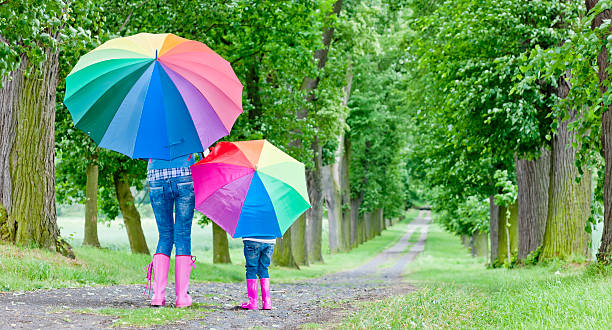 istock mother and daughter with umbrellas 141250586
