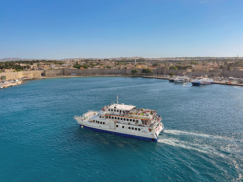 Rhodes, Greece - May 2022: High speed passenger ferry arriving in the harbour in Rhodes