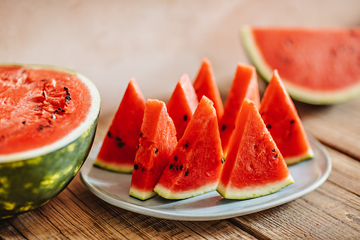 Sliced watermelon on a wooden table in a country house. A shot with a technique of shallow depth of focus.