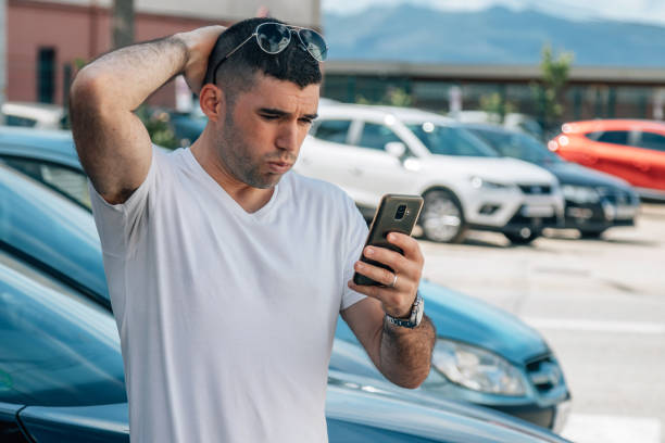 istock man buying car looking at mobile phone surprised or scared 1412518095