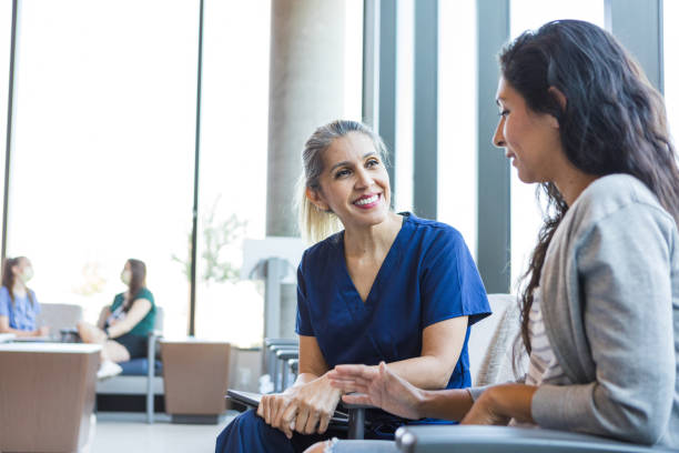 Doctor smiles as she listens to the patient The doctor smiles as she listens to the patient talk about her concerns for the upcoming procedure. medical office lobby stock pictures, royalty-free photos & images