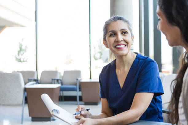 istock Medical assistant meets with female patient 1412518758