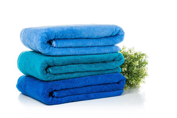 Close up view of a stack of three new blue towels isolated on white background. High resolution 42Mp studio digital capture taken with Sony A7rII and Sony FE 90mm f2.8 macro G OSS lens