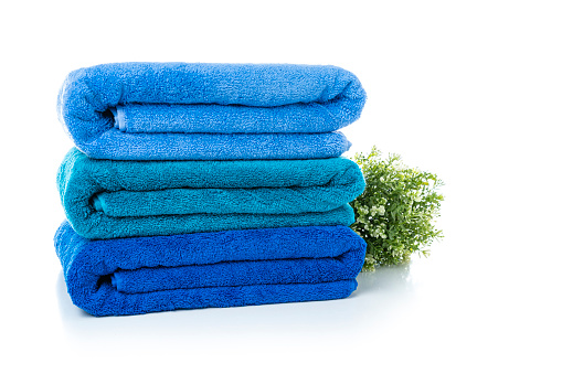 Close up view of a stack of three new blue towels isolated on white background. High resolution 42Mp studio digital capture taken with Sony A7rII and Sony FE 90mm f2.8 macro G OSS lens