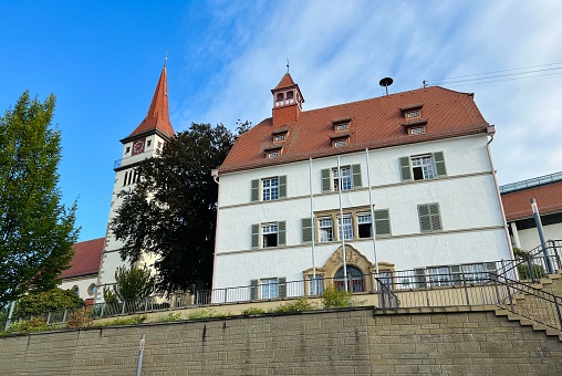 Ilsfeld, Germany - August, 1 - 2022: Town hall on the right side and the  Bartholomäus church on the left.