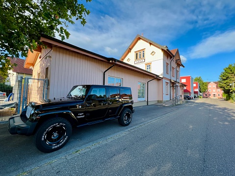 Ilsfeld, Germany - August, 1 - 2022: Black jeep parked at the old train station which now houses a doctor's premises.