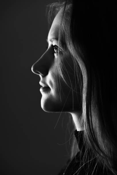istock Low light side view of woman studio portrait 1412520831