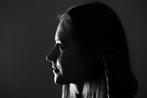 istock Low light side view of woman studio portrait 1412520838