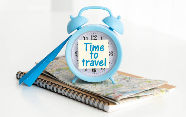 istock alarm clock on white background with text. Time to travel 1412523878