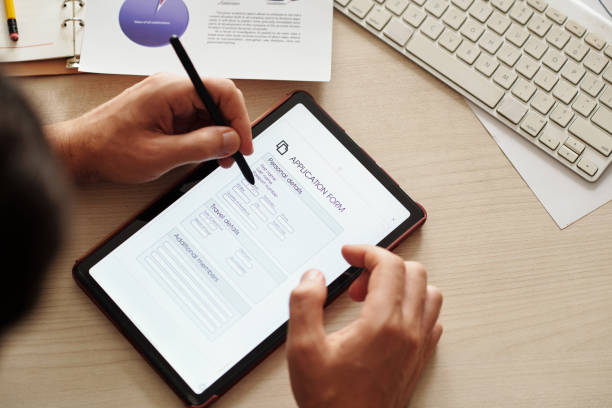 Businessman Filling Form to Get Visa Businessman filling application form on tablet computer to get visa for business trip form submission stock pictures, royalty-free photos & images