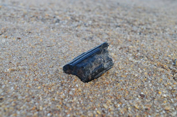istock Black tourmaline on sand background 1412524978